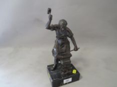 A bronze style model of a blacksmith on a marble base (small chip to base)