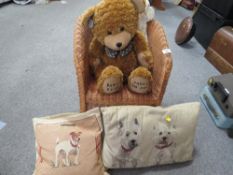 A wicker teddy bear chair together with a Darcy bear and cushions