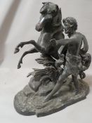 A large very heavy cast metal model of a man training a horse