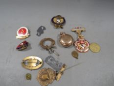 A gold plated sovereign case, enamel badges etc