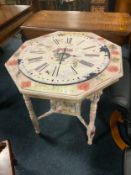 A decoupage style papered painted Edwardian table with attached clock