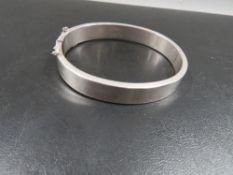 A hallmarked silver Charles Horner hinged bangle, with engraved decoration to the front panel