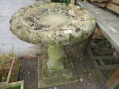 A large cast concrete bird bath