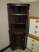 A dark wood stained corner cabinet