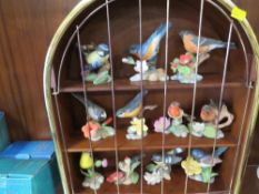 A display stand in the form of a bird cage containing 11 ceramic bird figures