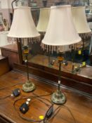 A pair of slender table lamps with shades