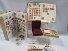 Two stamp albums to include Penny Black/Penny Red, postcards of QE2 and three packs of playing cards