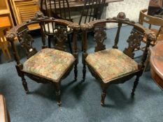 A pair of antique carved oak corner armchairs with mask head detail