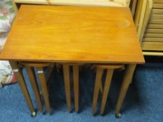 A retro teak nest of three tables
