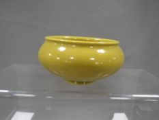 A small Chinese footed bowl in yellow/green colour with six character mark to base