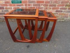 A retro teak nest of three glass topped tables in G-Plan Astro style design