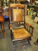 An Edwardian mahogany rocking chair with padded leather panels