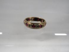A hallmarked 9 carat gold ruby and diamond eternity ring approx. weight 2.6g
