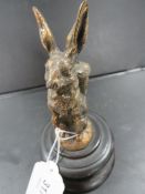 A novelty cast metal figure pen holder in the form of a hare carrying a wicker basket on his back on
