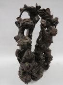 A carved Chinese hardwood figure of two characters one having a peach on his belt, the other with