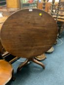 An antique mahogany tilt top table