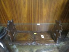 A carved wooden book slide with oak leaf and acorn detail