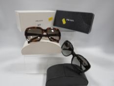 Two pairs of Prada sunglasses in original boxes