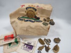 A selection of assorted military badges and buttons, embroidery cloths etc