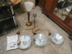 A modern Indian triple hanging light fitting together with a retro teak table lamp