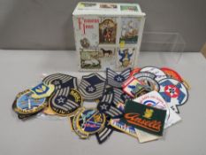 A tin of assorted military and cloth badges