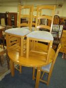 A modern light oak extending dining table and six chairs