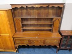 An antique oak and mahogany crossbanded Welsh dresser with three drawers, raised on cabriole legs