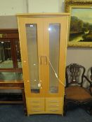 A modern beech display cabinet with drawers below H 186 cm W 74.5 cm