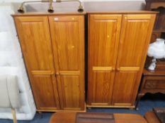 A pair of modern honey pine double wardrobes