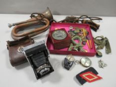 A tray of assorted militaria collectables to include a bugle, cap badges, etc