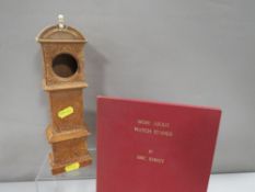 An antique treen pocket watch holder in the form of a miniature longcase clock with carved