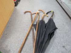 A selection of vintage walking sticks and umbrellas