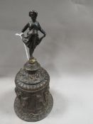 A Coalbrook style cast bell with figural handle and replacement clanger