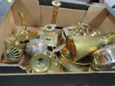 A tray of assorted metal ware to include a pair of ornate brass squat candlesticks