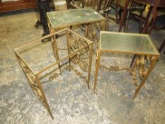 A nest of wrought iron and glass top tables