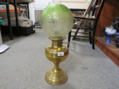 A vintage brass oil lamp together with a green etched shade