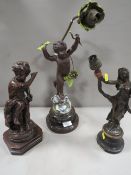 A cast metal cherubic lamp A/F together with a bronze effect lamp base and a cast metal figural lamp