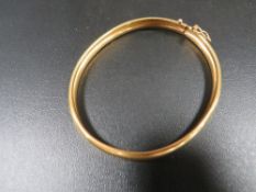 A yellow metal clasp bangle marked 916 approx. weight 12.9g