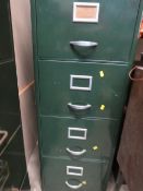 A vintage green four drawer filing cabinet