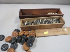 Two antique bone and ebony domino sets, in wooden boxes, together with turned wood draughts pieces