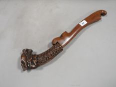 A vintage Far Eastern dagger with wooden scabbard and carved dragons head to handle