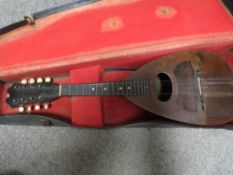 A cased mandolin with label inside