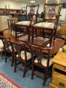 A reproduction mahogany extending twin pedestal dining table and eight chairs