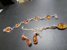 An amber and sterling silver bracelet, pendant on chain and earrings