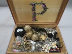 A treen box containing vintage costume jewellery