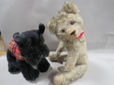 A vintage teddy bear together with a modern Scottie toy dog