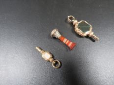 A small hard stone column seal together with two jewelled yellow metal watch winders (3)