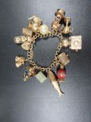 A vintage 9ct gold charm bracelet fitted with large 9ct gold charms, total weight approx. 75.2 g