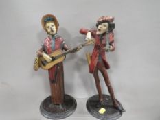 A pair of French cold painted spelter street musicians caricature candlesticks, both signed Francois