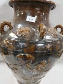 A large treacle glaze Oriental style vase with applied three toed dragon decoration